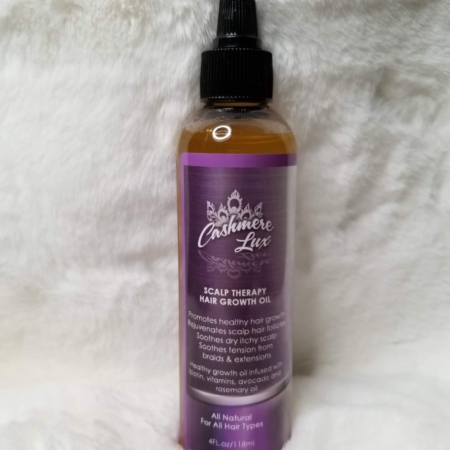 A bottle of Scalp Therapy Growth Oil on a white fur rug.