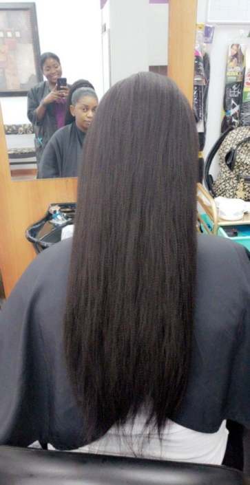 A woman with long black hair in a salon.