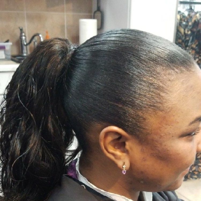 A woman's hair in a ponytail in a salon.