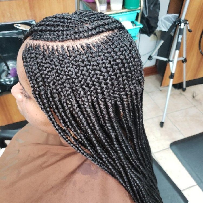 A woman with long braids in a salon.